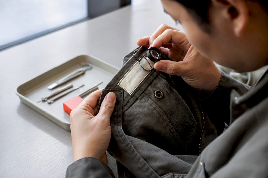 Inspector checking anonymous garment stitching and hardware