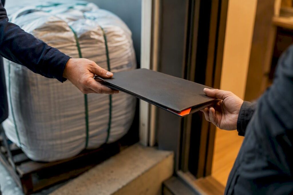 Contract folder exchanged beside textile export bale